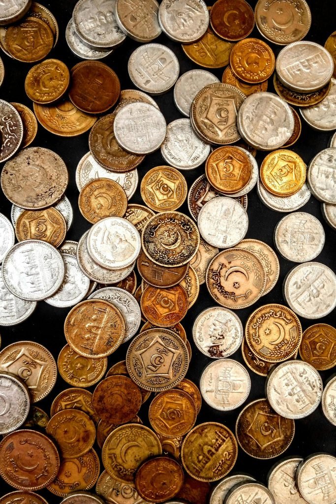 A diverse collection of vintage and collectible coins displayed on a surface, showcasing their varied designs and metallic textures.