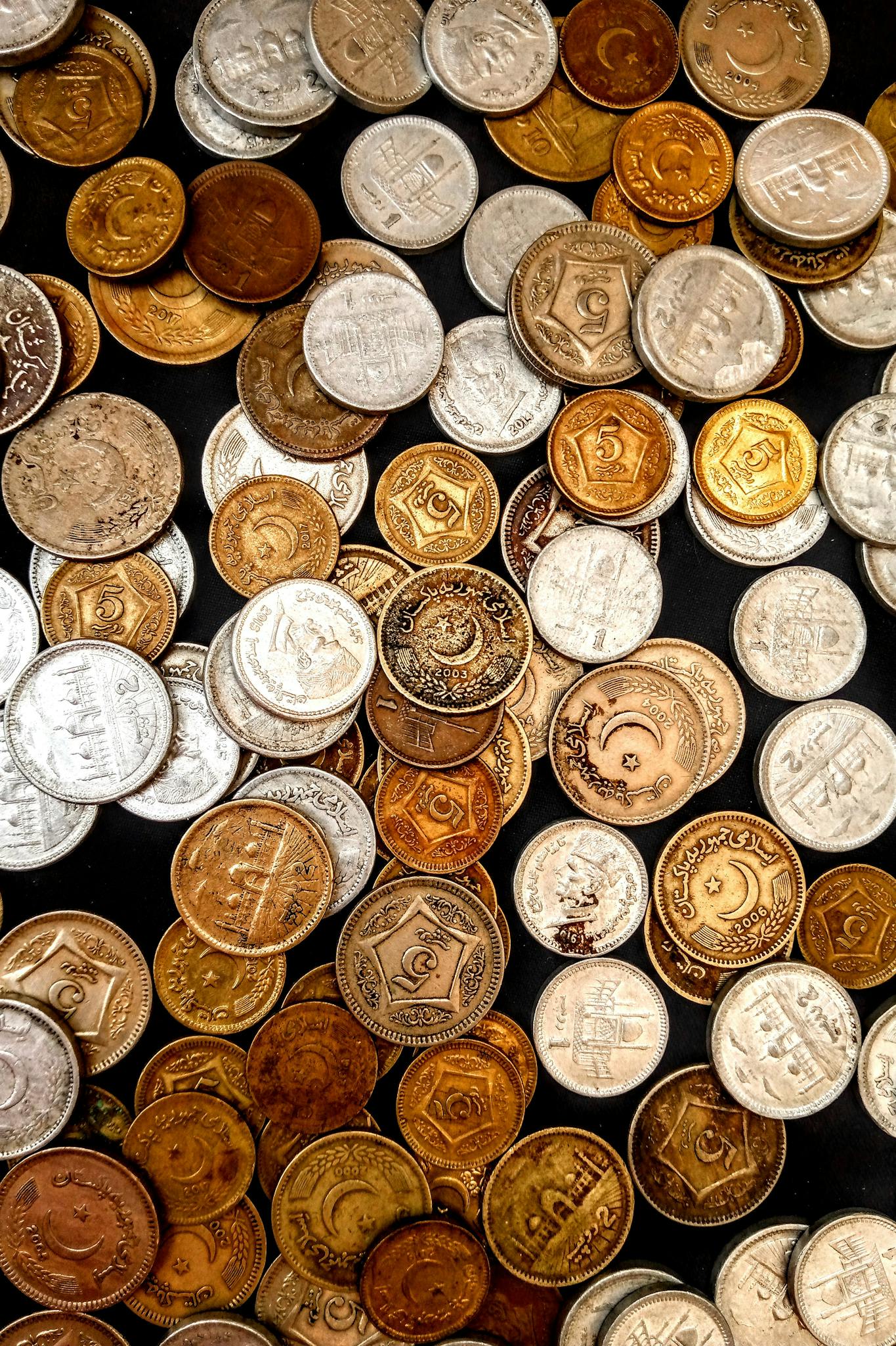 A diverse collection of vintage and collectible coins displayed on a surface, showcasing their varied designs and metallic textures.